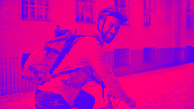 Happy young man commuter riding bicycle outdoors in city, looking at camera depicting Change Payment Method After Purchase